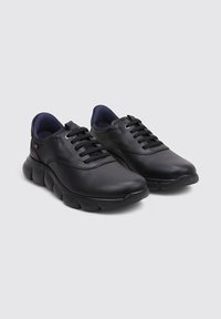 Zapatos de cuero negro con punta redonda, cordones planos y suela acolchada. El interior presenta un forro de un azul oscuro contrastante.