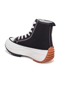Schwarze Canvas High-Top-Sneaker mit weißer Gummispitze und -sohle. Texturierter brauner Absatz mit Rillen, weißen Ösen und Schnürsenkeln.