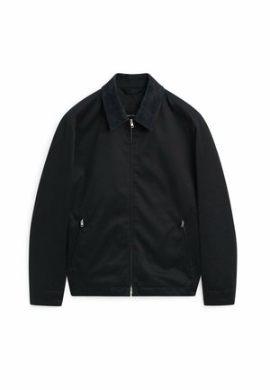 Veste noire en tissu lisse, avec un collier en suède foncé, fermeture éclair sur le devant et deux poches latérales avec fermetures éclair.