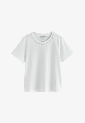 Bílé tričko s krátkými rukávy a kulatým výstřihem zdobené řadou malých bílých perel.