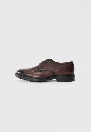 Zapato de vestir de cuero marrón con punta redondeada, diseño de cordones, acabado texturizado y suela de goma con un leve tacón.