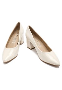 Beżowe lakierowane szpilki z noskiem w szpic i słupkowym obcasem, charakteryzujące się gładką fakturą i minimalistycznym designem.