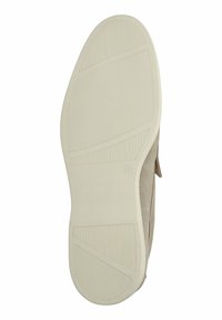 Zapato de ante beige con una suela de goma texturizada. Presenta un diseño moldeado y un branding sutil en la suela. Color dominante: blanco roto.
