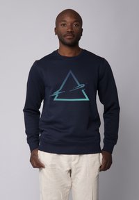 Sweatshirt marine avec un graphique triangulaire géométrique en dégradé de teintes. Il a des manches longues et un col rond, fabriqué à partir d'un matériau doux.