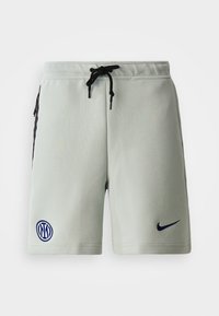 Lys grå træningsshorts med sorte sidepaneler, elastisk talje og snøre. Har logoer på venstre ben. Glat tekstur.