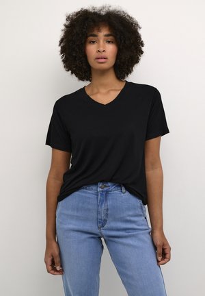 T-shirt noir à col en V avec des manches courtes, fabriqué en tissu doux. Assorti à un jean clair taille haute. Design sobre, sans motifs ni accents visibles.