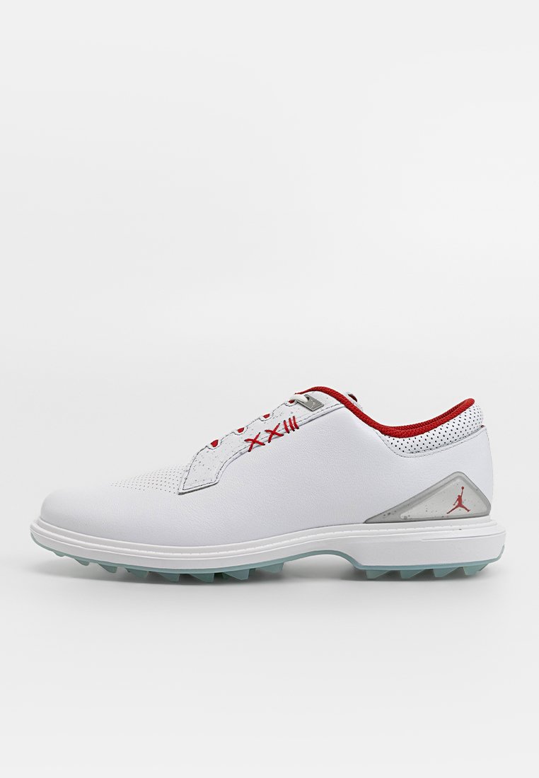 Chaussures de golf blanches avec des accents rouges, languette perforée et panneaux en mesh. Semelle en caoutchouc avec des crampons et détail en logo argenté sur le talon.