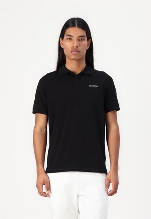 Polo nero in tessuto liscio, con colletto classico, maniche corte e un logo discreto sul petto. Design pulito e aderente.