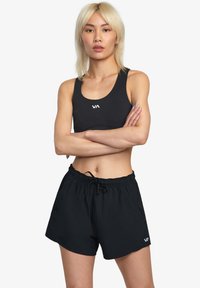 Sort atletisk crop top og shorts, lavet af letvægtigt stof. Har en rund halsudskæring og en elastisk talje med snørre.