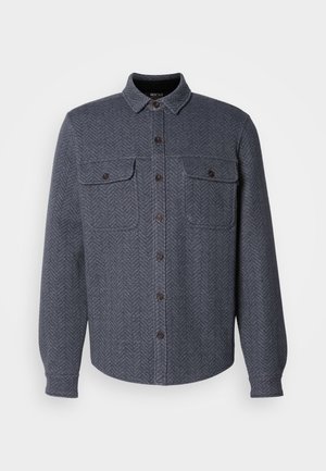 Dark gray flannel shirt featuring a herringbone pattern, a button-up front, two chest pockets, and button cuffs. Classic collar design.