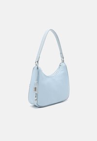 Borsa a mano azzurro chiaro con forma curva, texture liscia, manico corto e accessori in argento. Presenta una chiusura a zip e un piccolo dettaglio con etichetta.