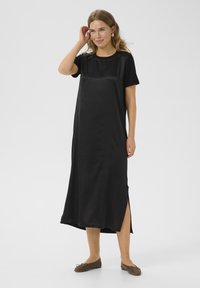 Black, satin-like dress with a round neckline, short sleeves, and side slits, featuring a loose fit and smooth texture.