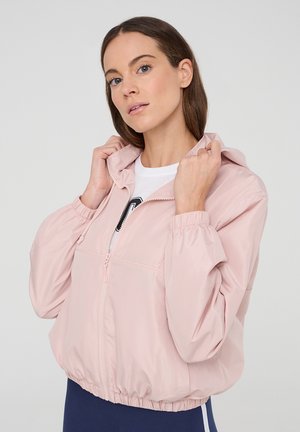 Giacca a zip rosa chiaro con cappuccio, polsini elasticizzati e vita arricciata, realizzata in un tessuto liscio; presenta una tasca frontale e un design a spacco.