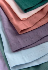Pachet de cămăși pliée în diverse culori: verde, roz, roz deschis, lavandă și albastru deschis. Material din bumbac cu tivuri cusute.