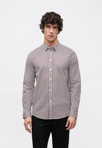 Camisa abotonada a rayas en blanco y burdeos, con cuello clásico, mangas largas y corte slim. Tejido de textura suave, diseño ajustado.