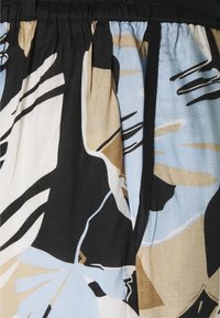 Tissu à imprimé floral présentant des couleurs bleu clair, beige et noir ; design plissé avec une taille élastique pour un ajustement réglable.