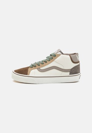Zapatilla de media caña con paneles de gamuza en beige, marrón y gris, cordones en verde oliva y una suela de goma blanca sobre un fondo blanco liso.