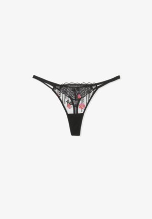 Black lace thong with floral embroidery in pink, featuring a sheer fabric front and scalloped edges, and narrow adjustable straps.
