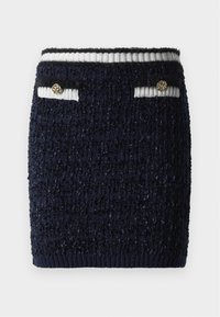 Gonna mini blu navy a trama con fascia in vita a righe bianche e blu navy e due piccole tasche frontali, ognuna con un bottone decorativo dorato.