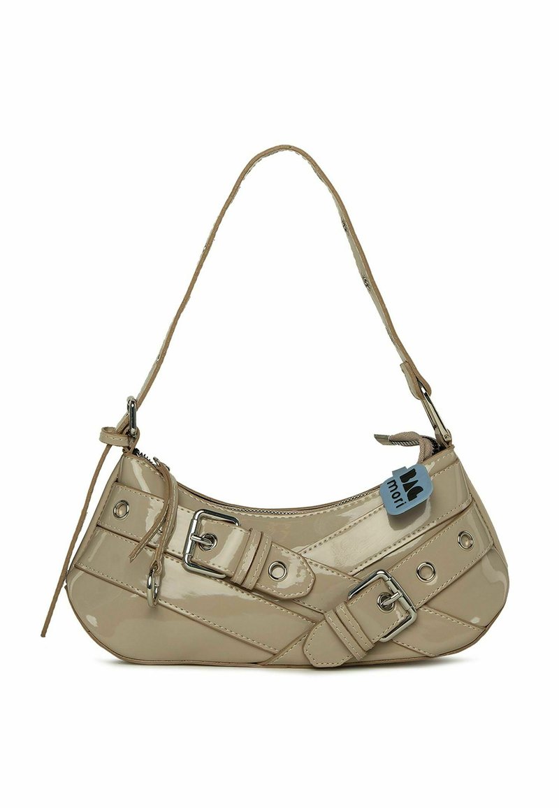Beige lackläderhandväska med en rundad form, justerbar rem, silverfärgad metalldetaljer, dekorativa spännen och cirkulära nitar.