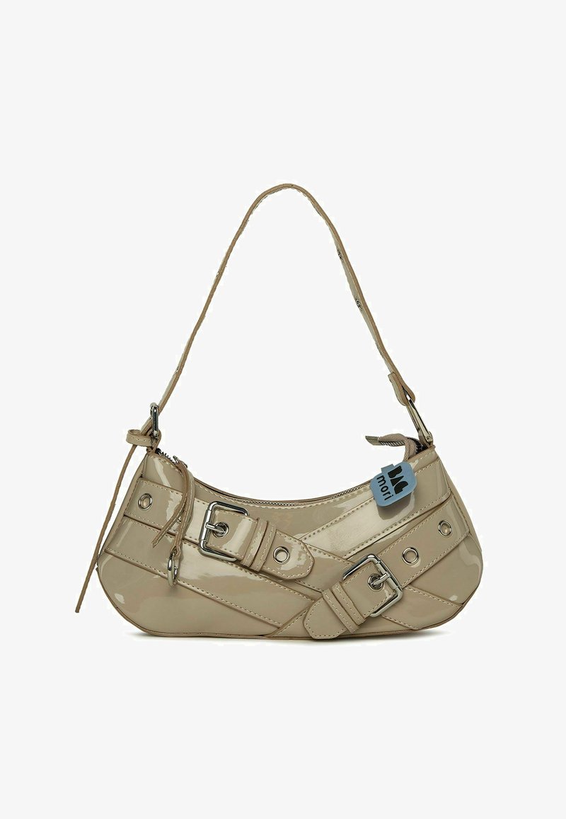 Sac à main en cuir verni beige avec une forme incurvée, une bandoulière réglable, des détails en métal argenté, des boucles décoratives et des clous ronds.