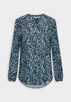 Blouse à manches longues en bleu clair avec un motif floral noir, décolleté en V et ourlet arrondi. Fabriquée en tissu léger.