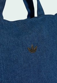 Borsa tote in jeans blu scuro con superficie testurizzata. Presenta due manici in tessuto e un dettaglio logo in metallo nero sulla parte anteriore.