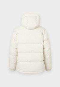 Balta pūsta žiemos striukė su kapišonu, matomomis horizontaliosiomis siūlėmis, elastingais rankogaliais ir iškilniu "North Face" logotipu dešinėje viršutinėje nugaros pusėje.