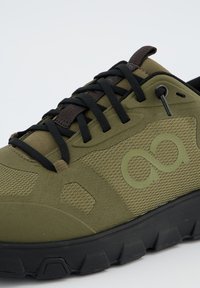 Olivově zelená sportovní obuv s texturovaným vrchním materiálem, černými šňůrkami a gumovou slou. Obsahuje detail loga a zesílenou špičku.