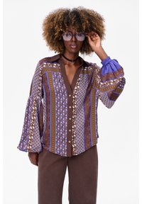 Multikleurige, gemusterde blouse in paars, bruin en wit met een knopenfront, klokmouwen en een klassieke kraag.