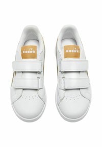 Un paio di sneakers bianche per bambini con due strap in velcro e toppe color tan sulle linguette, viste dall'alto su uno sfondo bianco.