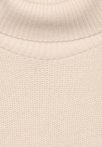 Sweter dzianinowy z wysokim, prążkowanym golfem w miękkim, jasnobeżowym kolorze. Posiada teksturowany, prążkowany wzór na całej powierzchni tkaniny.