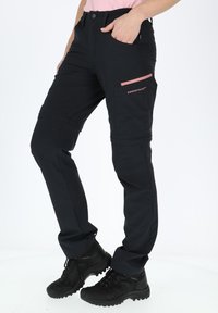 Black technical pants with a slim fit, featuring a pink zippered pocket and logo, made from durable stretch fabric. Suitable for outdoor use.