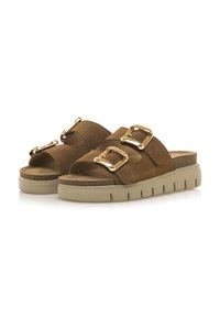 Le ciabatte in suede marrone presentano due ampie cinghie con dettagli in oro, sole in gomma beige chiaro a contrasto con scanalature orizzontali.