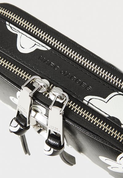 Sort lynlås taske med en glat læderoverflade og hvide grafiske detaljer. Sølvhardware inkluderer dobbelt lynlås og brand-tryk.