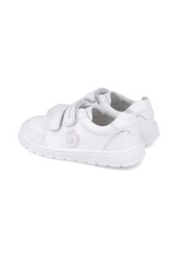 Zapatillas blancas de piel suave con dos cierres de velcro, punteras redondeadas y suela de goma texturizada. Logo de la marca grabado en el lateral.