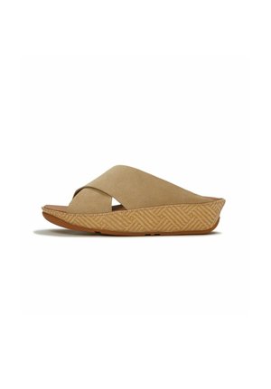 Sandalia tipo cuña en color tostado con tiras entrecruzadas y suela con patrón texturizado, estilo sin cierre, vista lateral en ángulo.