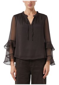 Zwarte blouse met een geplooide hoge kraag en 3/4 transparante mouwen met gelaagde ruches. Zachte stof die zorgt voor een losse pasvorm.