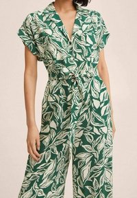 Mono verde con estampado floral, hecho de una tela ligera, que presenta un cuello con solapa, mangas cortas y una cintura ceñida con cinturón para un aspecto ajustado.