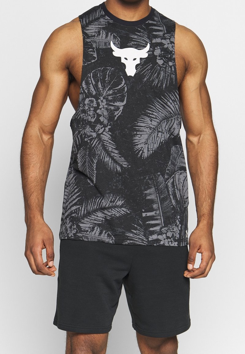 Bezramkowy czarny podkoszulek z szarym tropikalnym wzorem liści i białym logo czaszki byka na piersi; w połączeniu z ciemnymi szortami.