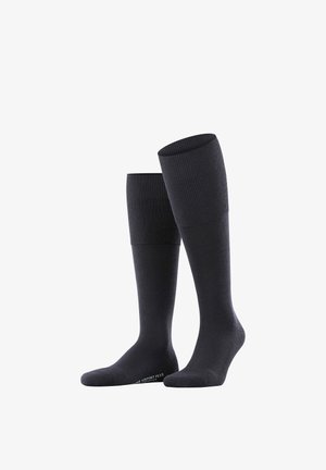 Calzini fino al ginocchio di colore grigio scuro con una texture a coste nella parte superiore e materiale liscio sotto. Presentano un logo alla caviglia.