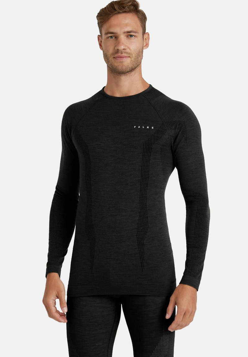 Zwart sportshirt met lange mouwen, voorzien van textuurpanelen, geribbelde accenten en een subtiele logo op de borst. Geschikt voor actieve kleding.