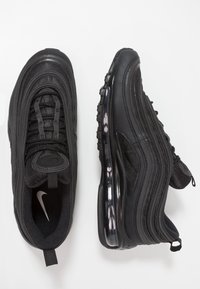 Zapatillas negras Nike Air Max 97 con parte superior de malla texturizada, acentos reflectantes y una unidad de amortiguación de aire visible en la suela.