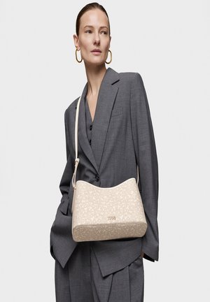 Bolso de mano beige con un diseño estructurado, textura suave y una sola correa para el hombro, con un sutil logo en la parte delantera.