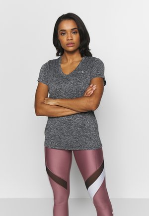 Camiseta gris de manga corta con escote en V y acabado texturizado, combinada con leggings rosas que presentan patrones en bloques de color y acentos de malla.