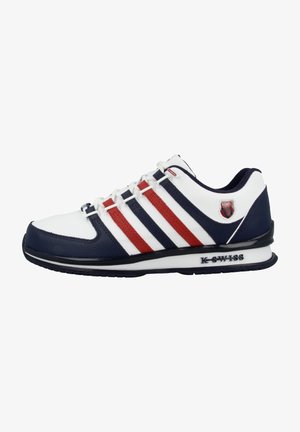 Chaussure de sport blanche avec des accents bleu marine et rouge, présentant une texture lisse, trois rayures diagonales et une semelle en caoutchouc avec le logo 'K-Swiss'.