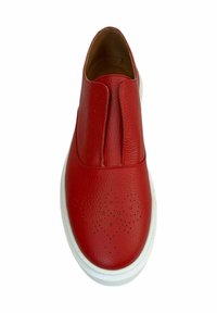Zapato rojo de piel sin cordones con una superficie texturizada, punta redondeada y suela de goma blanca. Los detalles perforados añaden interés visual.