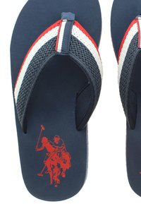 Námořnické žabky s červenobílou pruhovanou síťovou páskou, na podrážce s grafikou červeného hráče póla. Lehký design a gumový materiál.