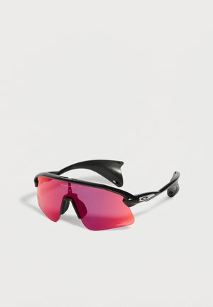 Αθλητικά γυαλιά ηλίου με μαύρο σκελετό, ενιαίο καμπυλωτό κόκκινο φακό και λογότυπο Oakley στον βραχίονα, τοποθετημένα σε λευκή επιφάνεια.