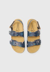 Blå sandaler med romfartsinspirerte mønstre, med to justerbare spenner, en korksåle og et flatt design. Størrelse 31.